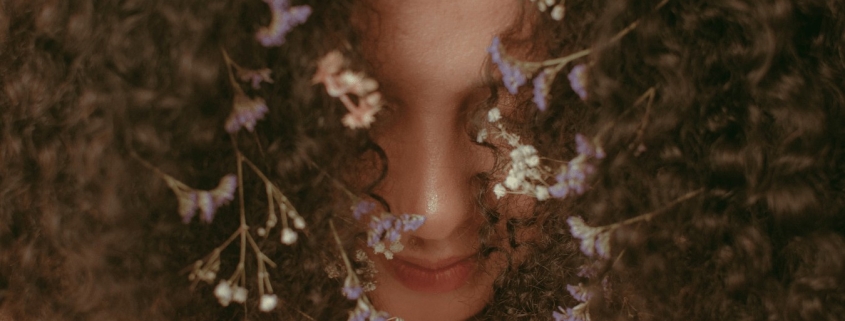 Donna con fiori tra i capelli, rappresenta la connessione alla Dea Madre
