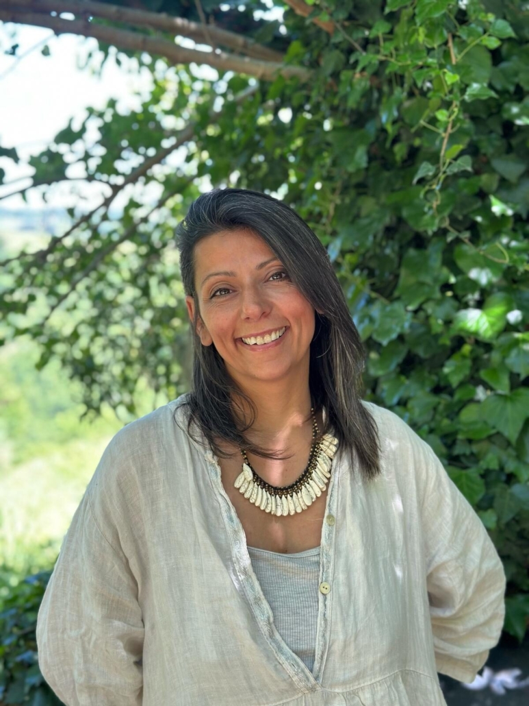 Sonia La Marca sorride immersa nella natura, ritratto dell'autrice del libro Il Risveglio della Grande Madre e guida nel percorso di guarigione interiore.
